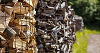 Holzscheite in einem Gitter, im Freien gestapelt.